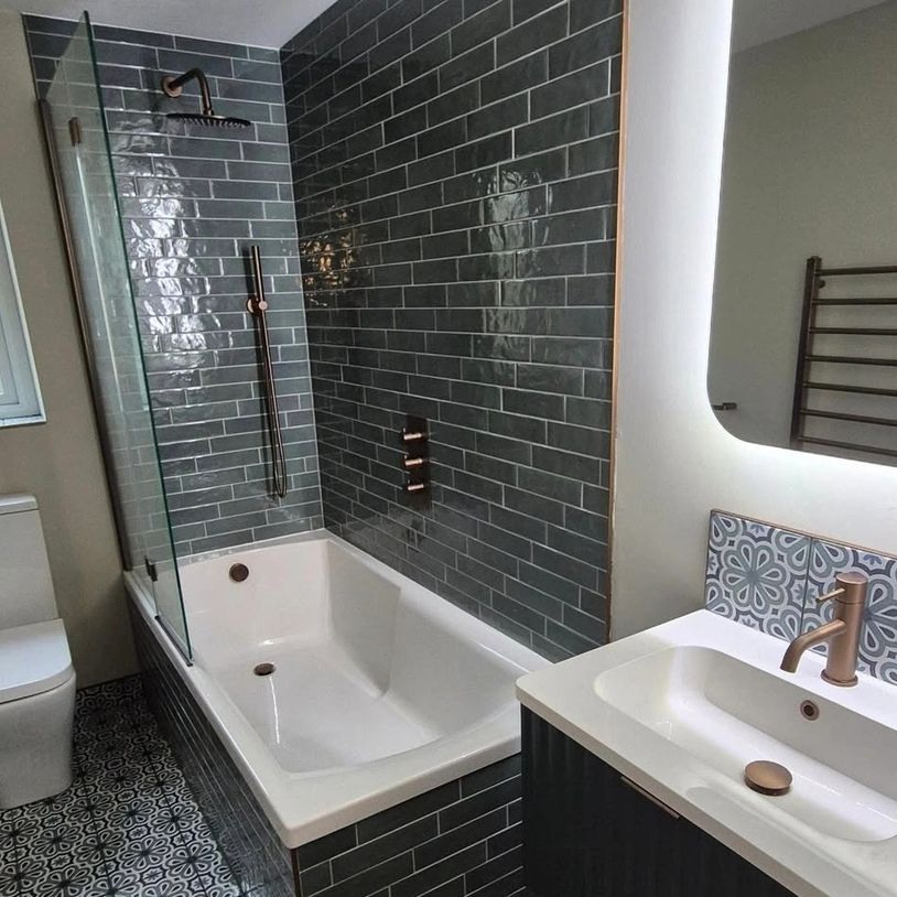 Modern bathroom with gray tiles and rose gold fixtures.