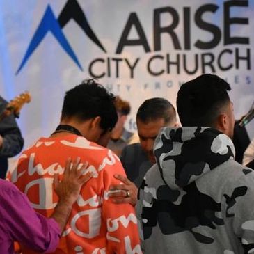 People praying together at Arise City Church event.