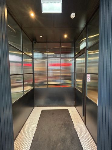Small entryway with black walls and textured glass panels.