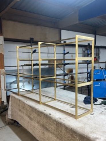Metal frame structure on a table in a workshop.