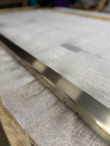 Close-up of a metal rod on a textured surface.