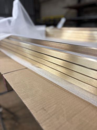 Close-up of polished metal strips on cardboard.