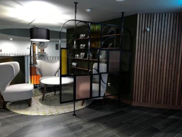 Modern lounge seating area with patterned rug and decorative divider.