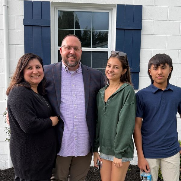 Family standing together outside a house.