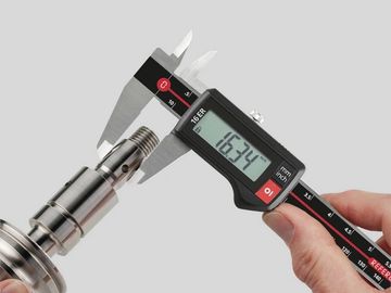 Digital caliper measuring a metal shaft's diameter accurately.