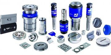 Various precision metal components and tools arranged on a white surface.