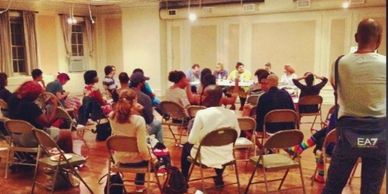 Group meeting in a room with chairs arranged in a circle.