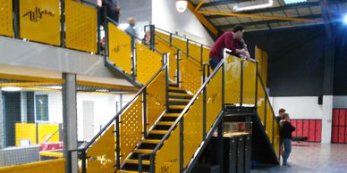 Mezzanine floor with triple flight stair edged with steel handrail and lasercut infills in Kent.