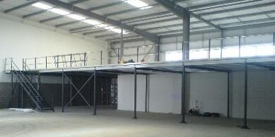 A completed braced storage mezzanine floor with  handrail and staircase. 