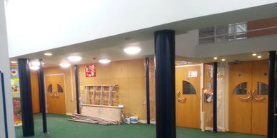 Mezzanine floor with MF ceiling and exposed intumescent painted circular columns in a Surrey school.