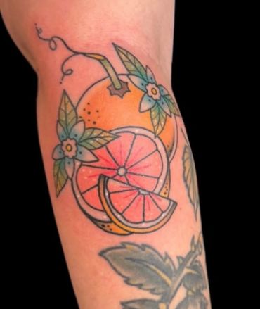 Tattoo of an orange with flowers on the arm.