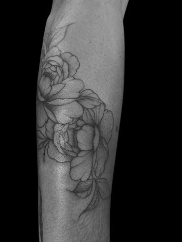 Black and gray floral tattoo on forearm.