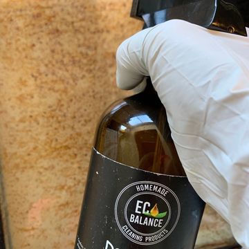 Hand holding Eco Balance cleaning product bottle.