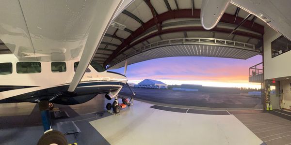 Daybreak over KFHR from inside Island Air's hangar, showing a Cessna Caravan executive charter plane
