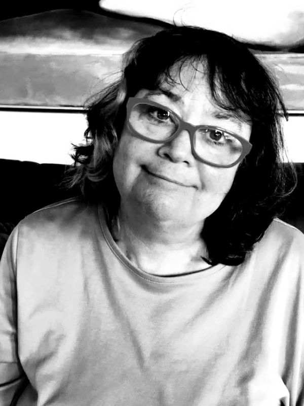 Smiling woman wearing glasses in a black and white photo.