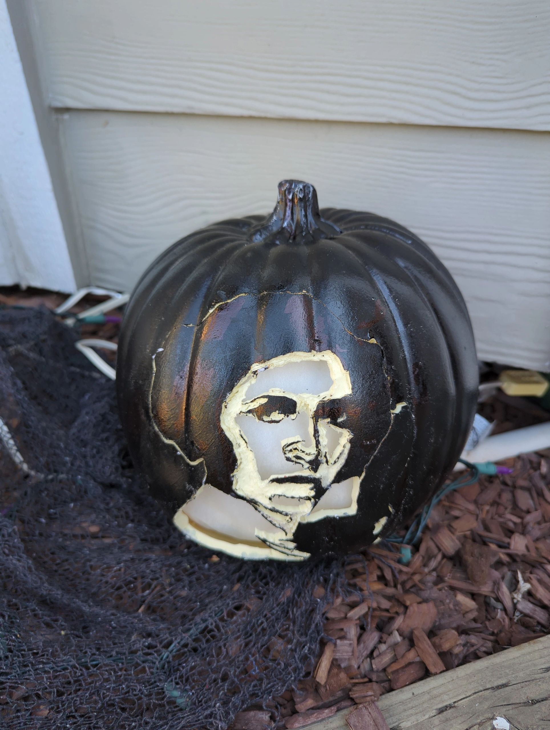 Black pumpkin with a carved face.