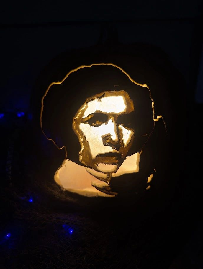 Pumpkin carved with a detailed human face portrait.