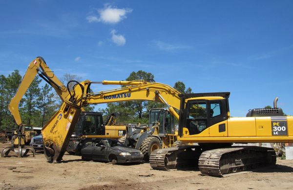 Yellow Komatsu excavator on a construction site with other heavy machinery.