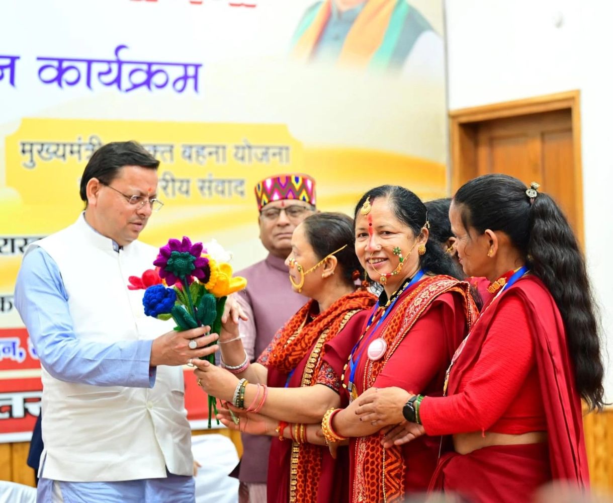 A man receiving a bouquet from women in traditional attire at an event.