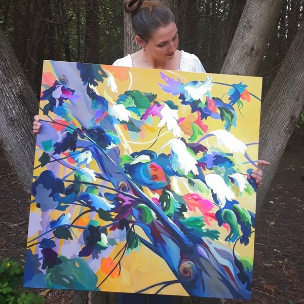 Modern art painting of colorful tree being held by artist in the forest.