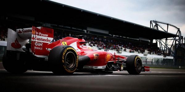 Red Ferrari Formula 1 racing car on track with crowd in background.