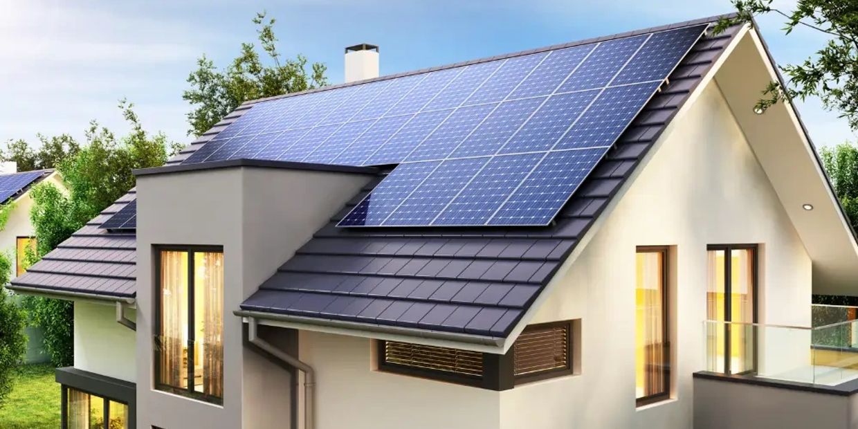 Modern house with solar panels on the roof under a clear sky.