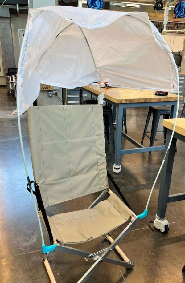 Portable chair with a sunshade canopy indoors.