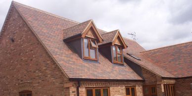 Plain-tile roof on a new roof in Oulton Broad, Lowestoft using new tiles. Dormers with lead sides