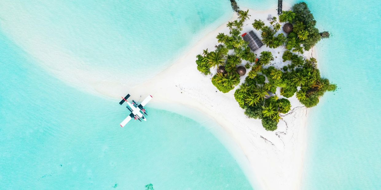 A seaplane beached docked at a tiny private beach resort in maldives 