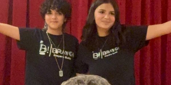 Two young people in black Bravo Players Club shirts.