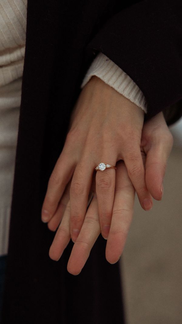 Hands showing an engagement ring.