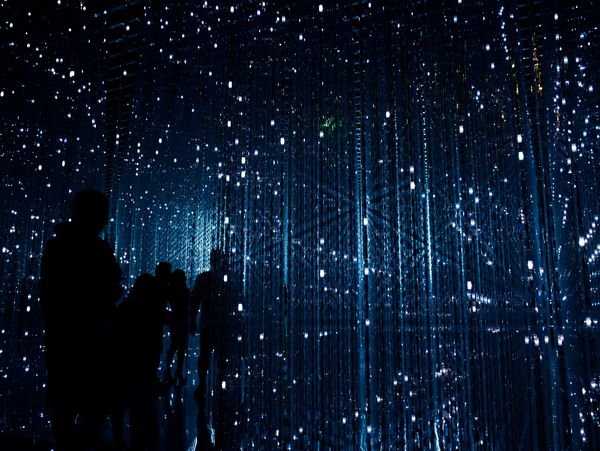 Blue futuristic lights with silhouetted figures, representing connected leadership and collaborative transformation