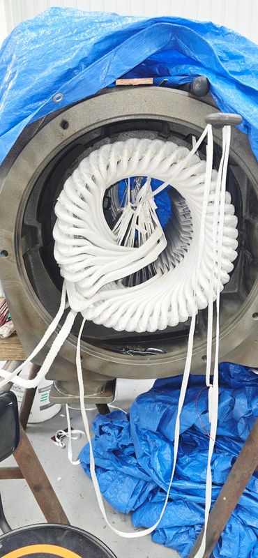 Coiled white rope inside circular metal structure.