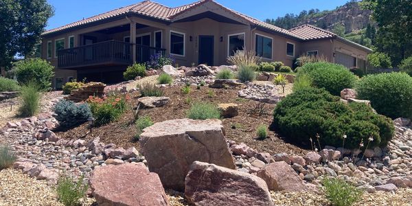House with a rocky and shrub-filled front yard.