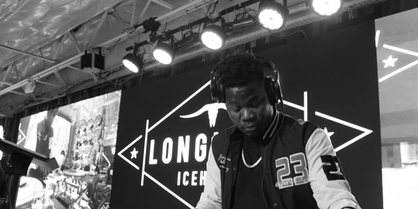 DJ mixing music at Longhorn Icehouse event with focused expression.