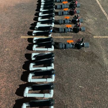 Row of electric scooters lined up on pavement at night.