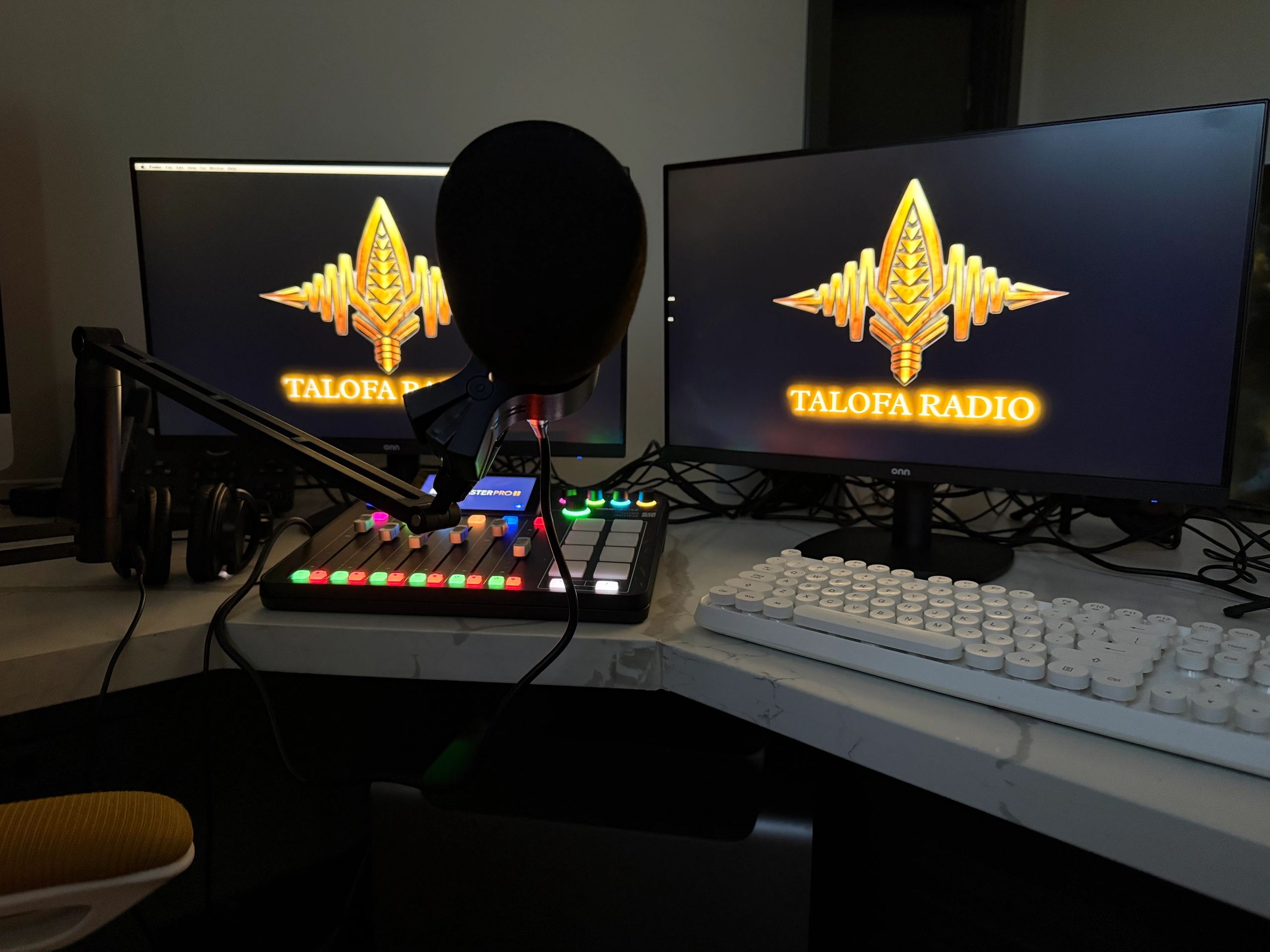 Podcast setup with dual monitors and microphone