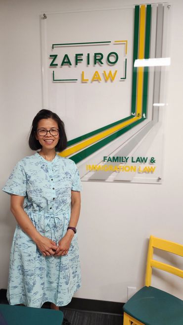 Woman standing in front of Zafiro Law sign.