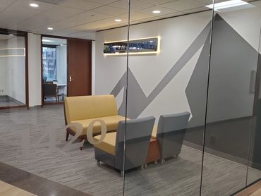 Modern office lobby with seating and glass walls.