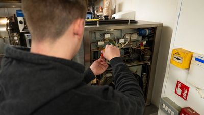 Person repairing an electrical panel.