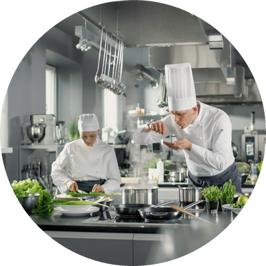 Two chefs preparing food in a professional kitchen with fresh ingredients.