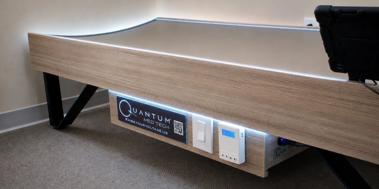 Modern Quantum Med-Tech device with illuminated control panel and sleek wood finish.