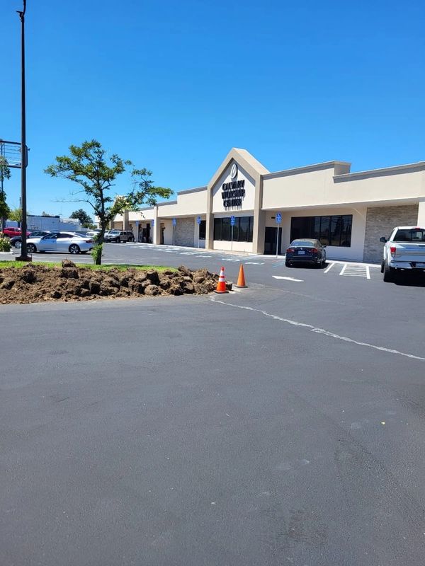 Empty parking lot with a church building under a clear blue sky.