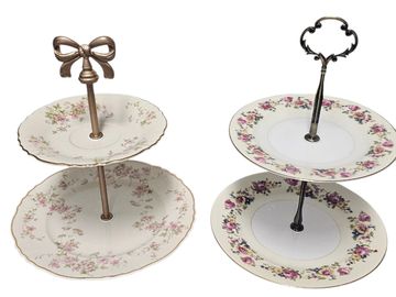 Two vintage two-tiered serving trays with floral patterns and decorative handles.