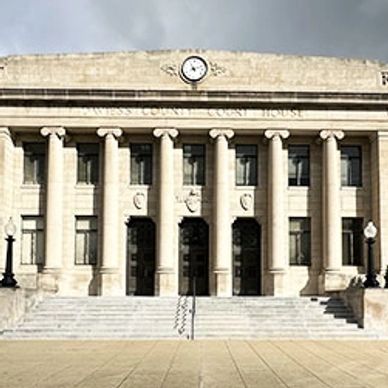 Front view of a classical courthouse building with columns and a clock.