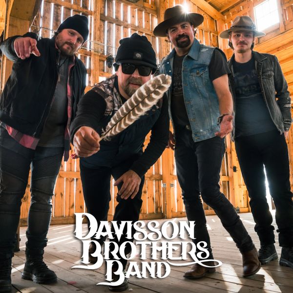 Davisson Brothers Band posing in a rustic wooden barn with a feather.