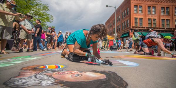 Artist drawing image of child using chalk