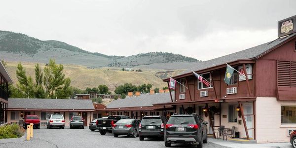 Cars park in front of affordable motel rooms at Yellowstone River Motel in Gardiner Montana, AAA.