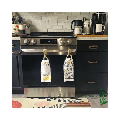 Cozy, clean kitchen with towels on oven, wood counters, coffee station, and Neat & Nimble logo.