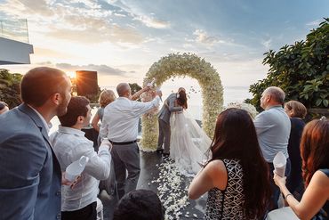 Just married under the floral arch — surrounded by love, laughter, and flying petals.